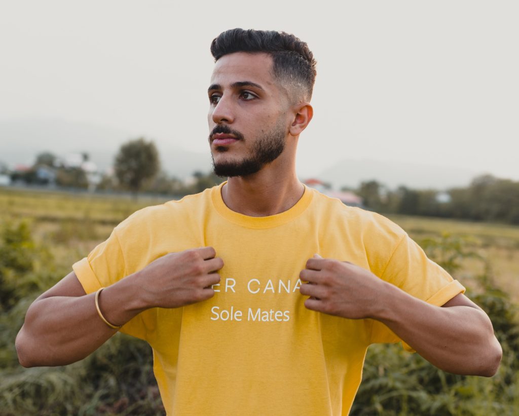 Man in a yellow shirt with white writing
