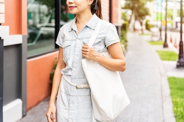 Young lady carrying a tote bag that is environmentally conscious and eco-friendly promotional items