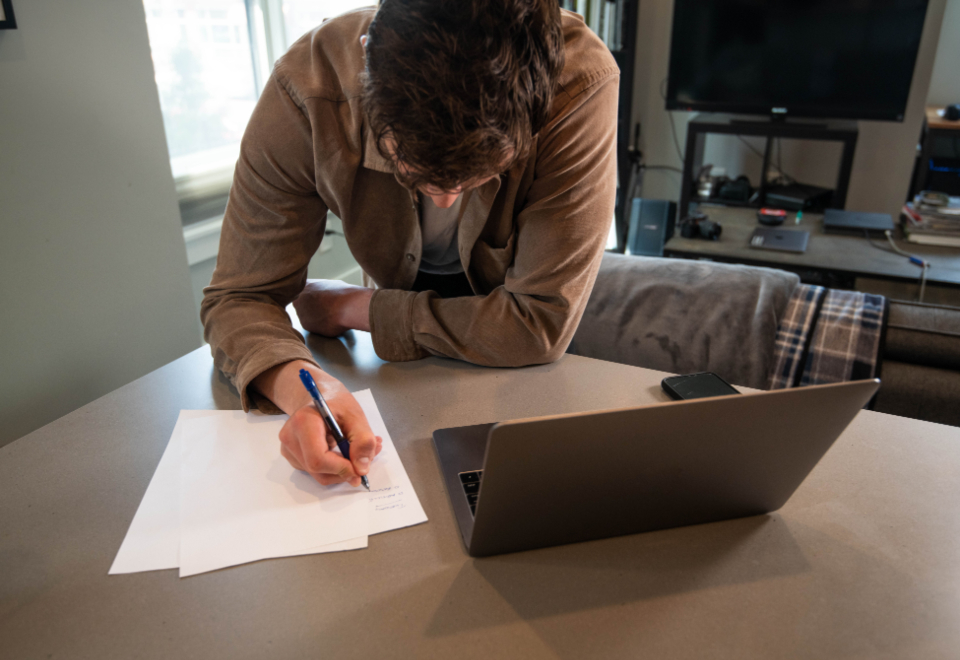 Man writing a plan with a branded pen on a piece of paper